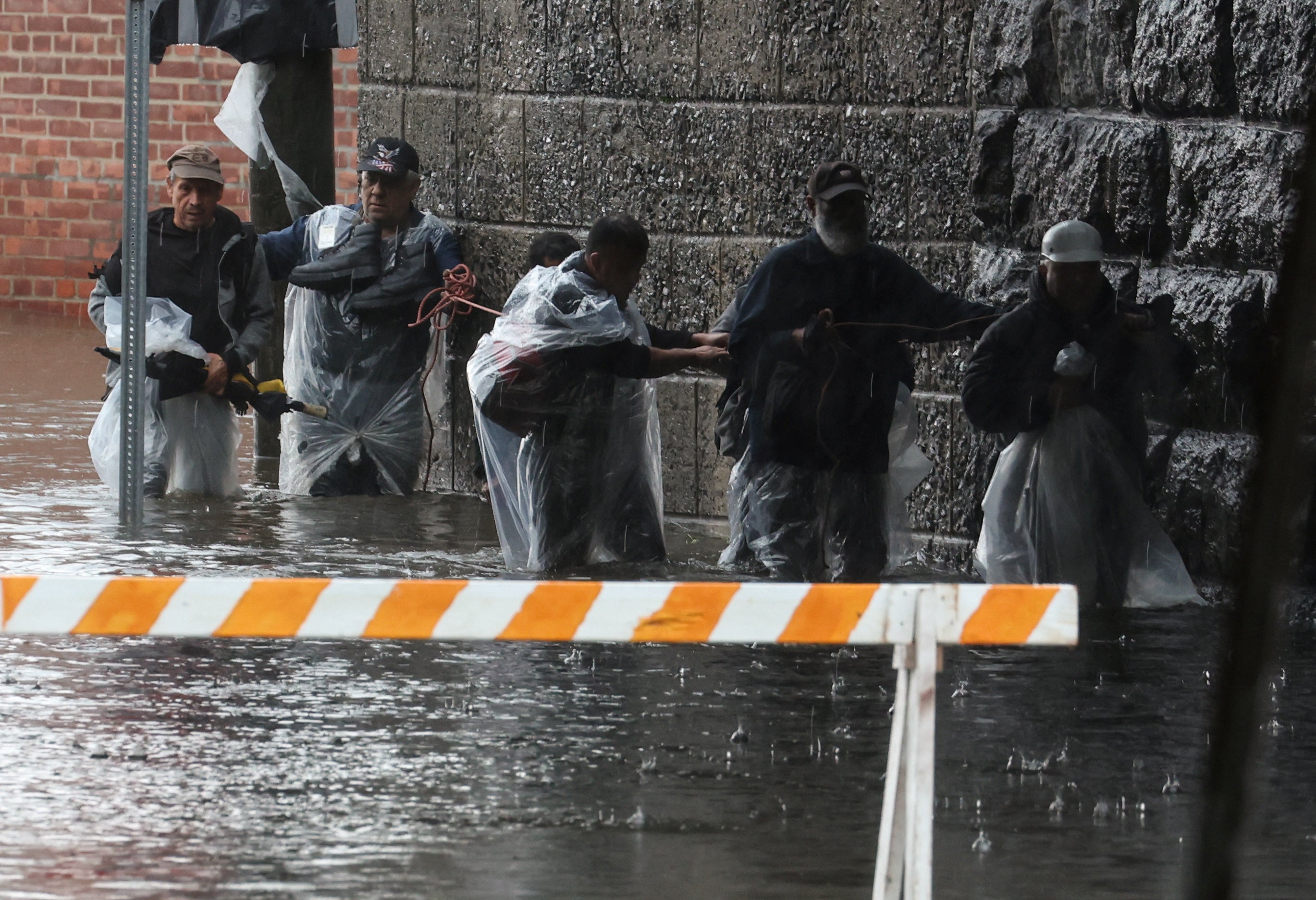 Residentes huyen de las crecientes inundaciones durante una intensa tormenta en el suburbio de Mamroneck en el condado de Westchester, Nueva York